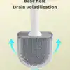 Brosse WC murale blanche avec système d'écoulement pour éviter l'accumulation d'eau.