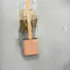 Brosse toilette flexible rose pâle, emballée dans un film plastique transparent.