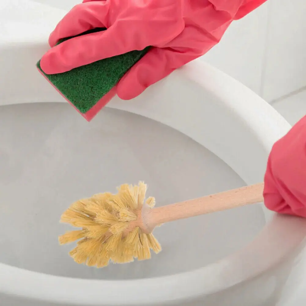 Brosse WC manche bois en action, nettoyage toilette avec gants roses.