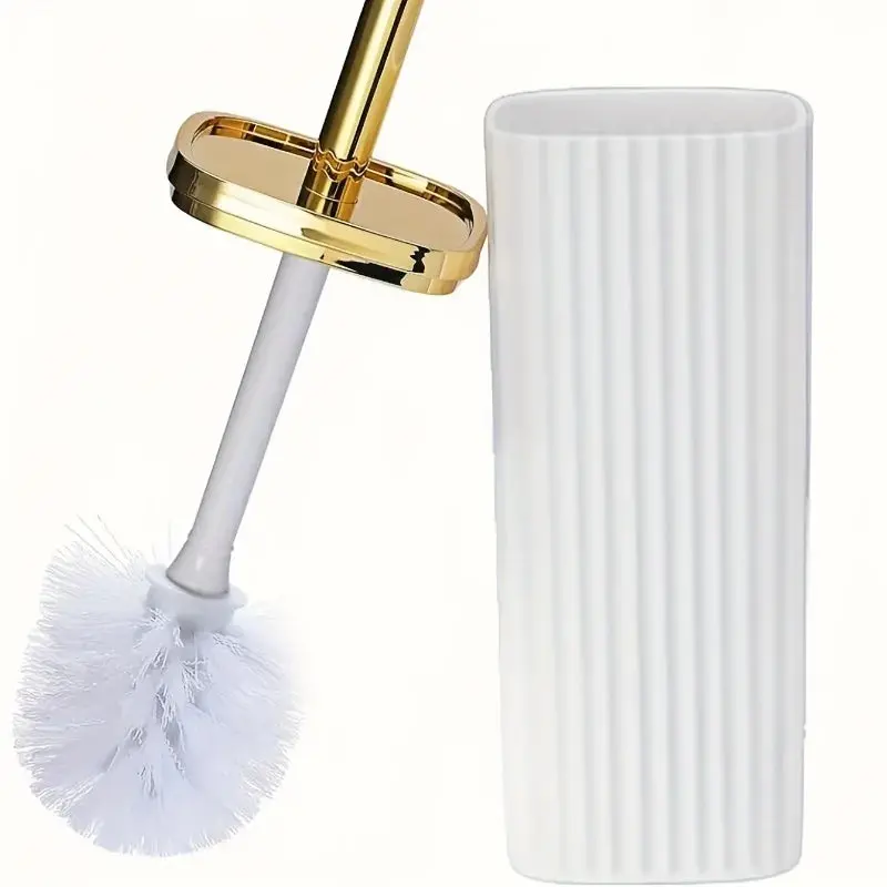 Brosse WC blanche avec manche doré et support blanc rayé.