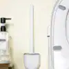 Brosse WC murale blanche, design minimaliste, fixée au mur près de la cuvette.