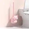 Porte brosse WC rose en forme de chat mignon, fixé au mur près de la cuvette.